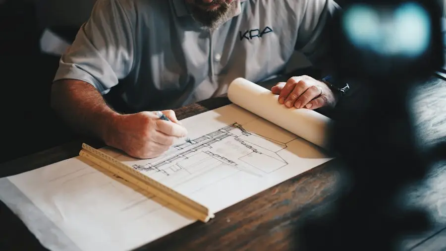 A contractor reviews building plans at a desk